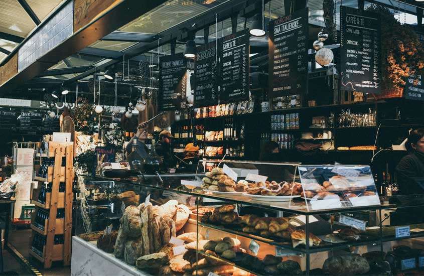Mercado com lojas de comida, pães e bebidas expostos