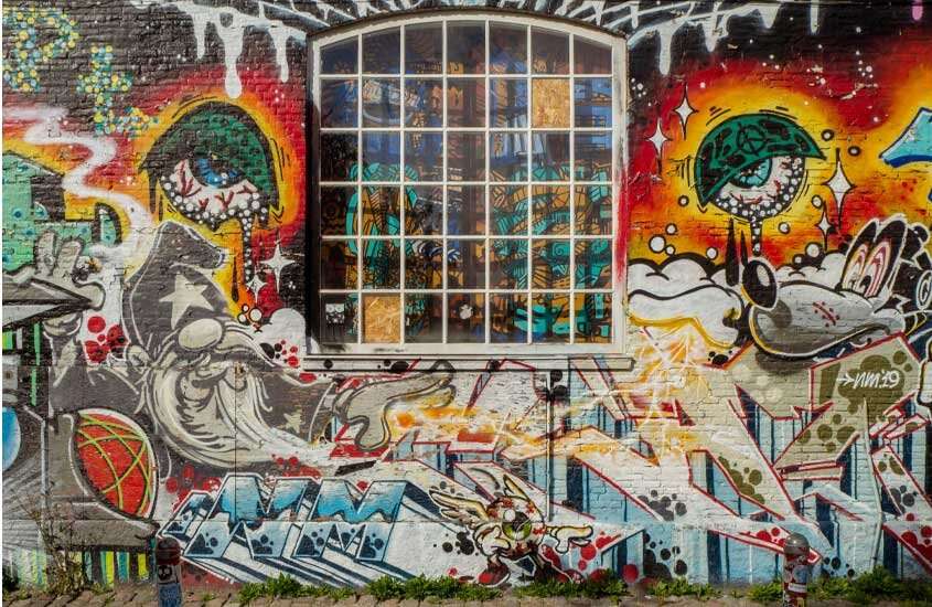 Parede com grafites pintados e janela grande em duas da cidade de copenhague