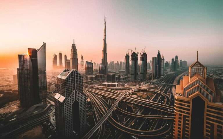 Em um final de tarda, vista aérea de Dubai com prédios, ruas e carros ao redor