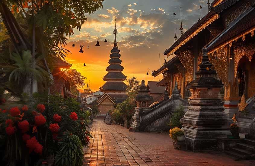 Durante o por do sol, paisagem da antiga cidade de Chiang Mai com monumento, plantas árvores e construções ao redor