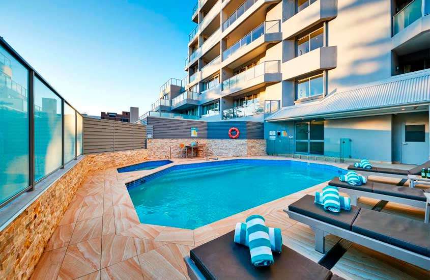 Em um final de tarde, área de lazer de um dos hotéis em Sydney com piscinas, espreguiçadeiras e toalhas