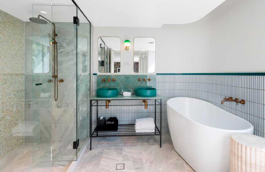 Banheiro de um dos hotéis em Sydney com banheira, box, duas pias, toalhas e espelhos