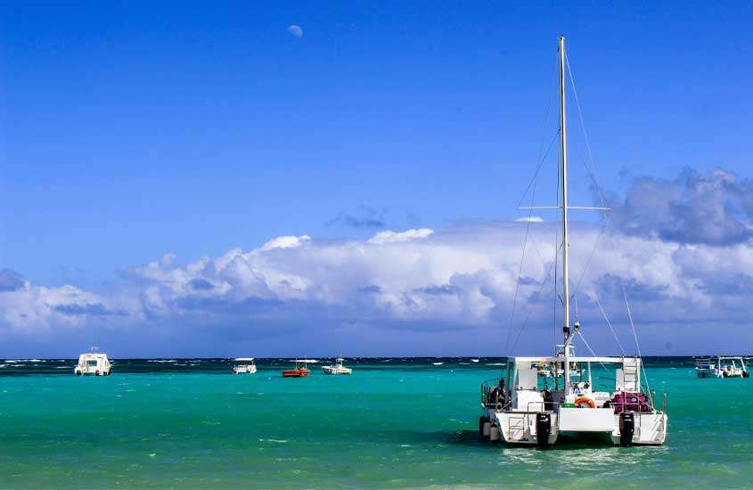 Em um dia de sol, passeios de catamarã com outros barcos ao redor no mar azul, um passeio interessante de o que fazer em punta cana