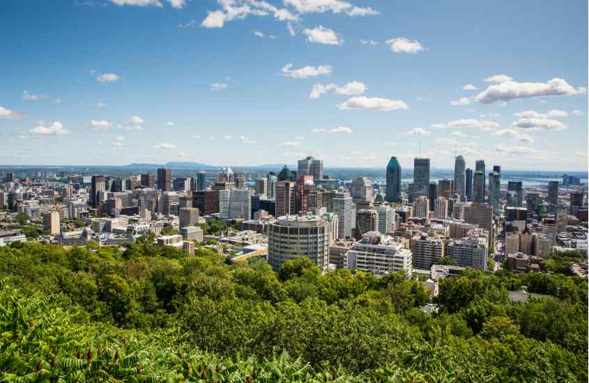 Em um dia ensolarado, vista aéres da cidade de Quebec com prédios grandes e árvores ao redor