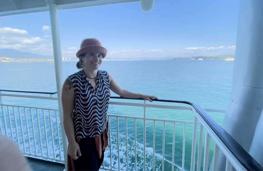 Em um dia ensolarado, Babi em Ferry com paisagem da ilha