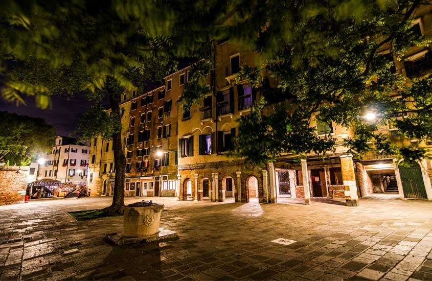 Durante a noite, cidade de Veneza iluminada com árvores ao redor