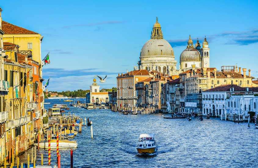 Durante um dia de sol, paisagem da cidade de Veneza com barco no canal e construção ao redor
