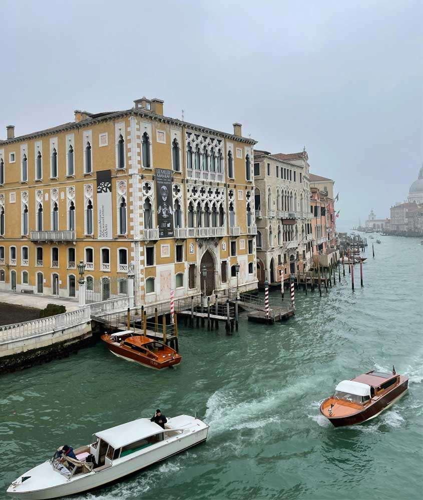 Em um dia nublado, vista de um dos pontos turísticos em Veneza com barcos na frente