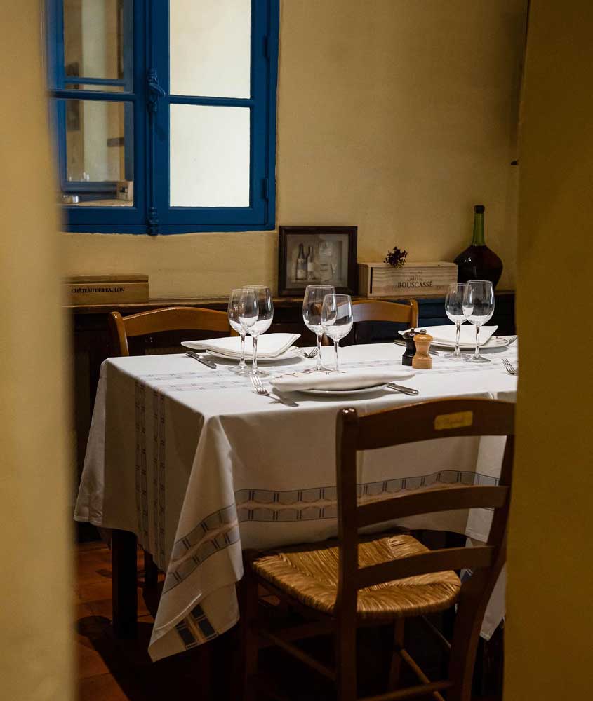 Interior de um dos restaurantes em Bordeaux com mesa posta e janelas grandes