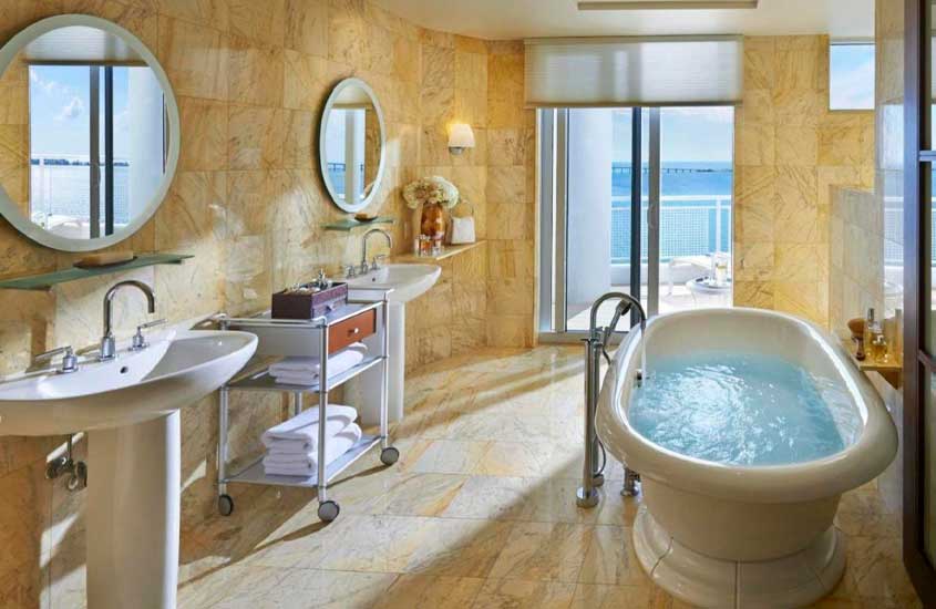 Banheiro de hotel para passar o réveillon em miami com banheira, duas pias, toalhas e varanda grande