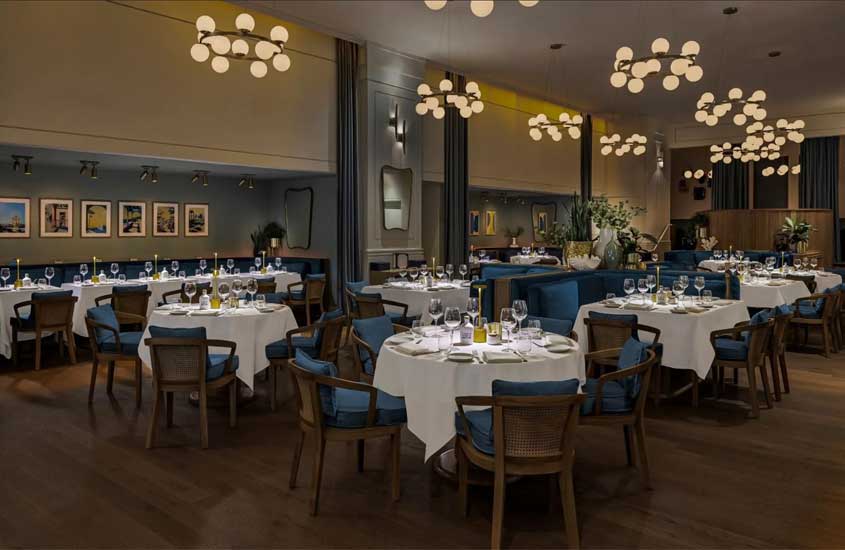 Interior de restaurante para passar o reveillon miami com mesas, cadeiras, plantas ao redor e quadros decorativos