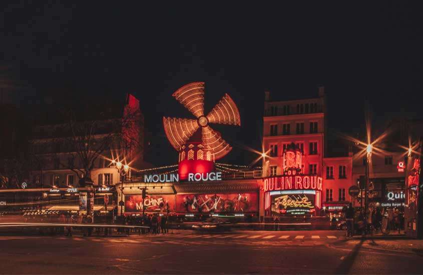 Durante a noite, fachada do Moulin Rouge, um dos lugares para passar o Réveillon em Paris