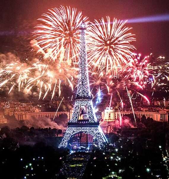 Durante a noite de Réveillon em Paris torre eiffel iluminada com fogos de artifício atrás
