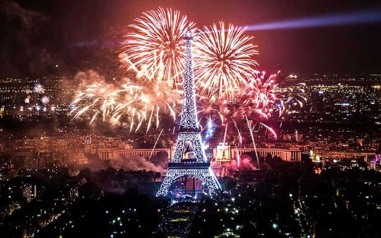 Durante a noite de Réveillon em Paris torre eiffel iluminada com fogos de artifício atrás