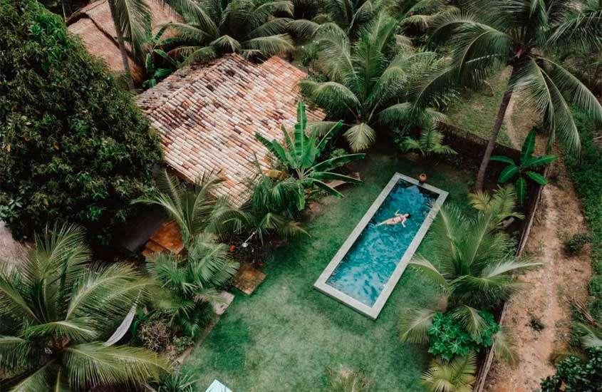 Área de lazer de um dos hoteis em Alagoas cim piscina, plantas e árvores ao redor