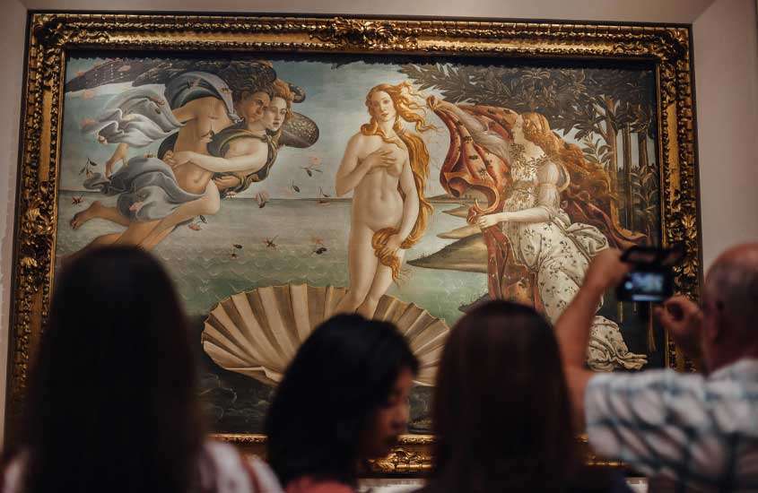 Exposição do Nascimento de Vênus na Galleria degli Uffizi, um dos pontos turísticos em Florença, com pessoas ao redor