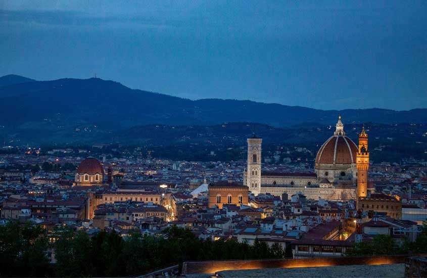 Durante o anoitecer, paisagem da cidade de Florença iluminada por luzes amarelas vista do Forte di Belvedere