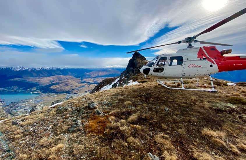 Em um dia de sol, helicóptero passeando pelos Alpes do Sul com paisagem da cidade