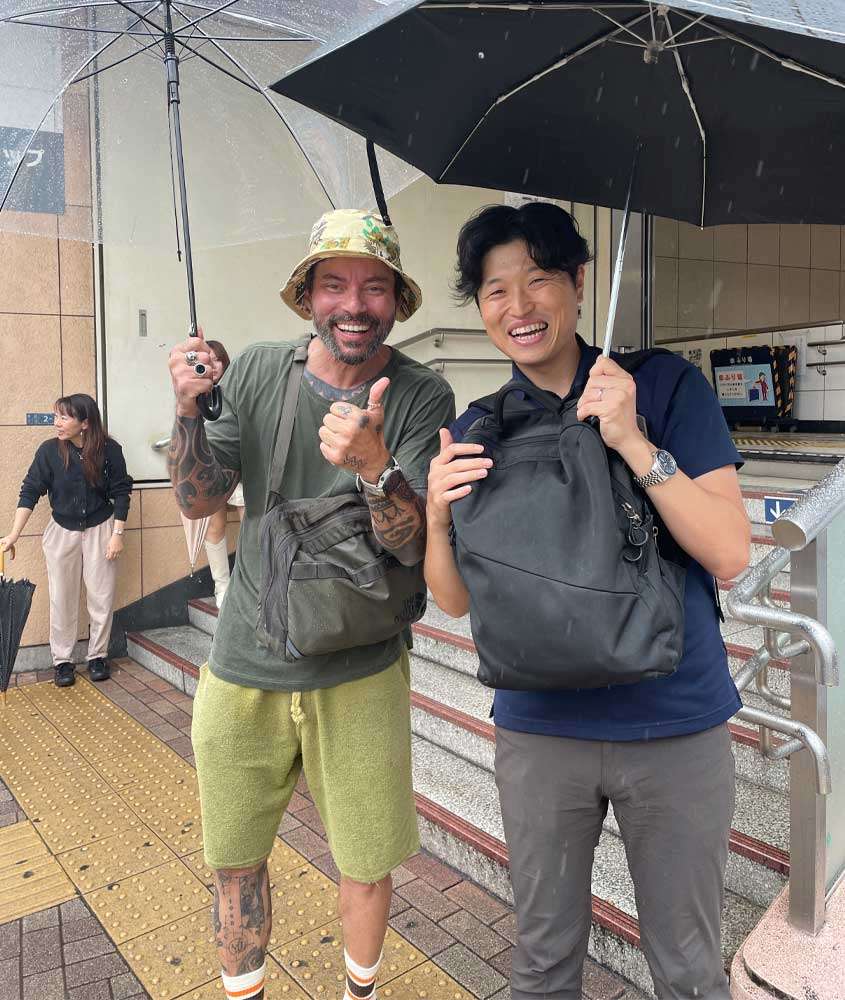 Vagner com amigo japonês na chuva em uma escadaria de Tokyo