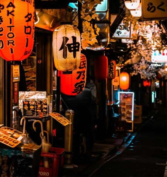 Rua famosa para visitar tokyo com restaurantes, árvores e luminárias tradicionais