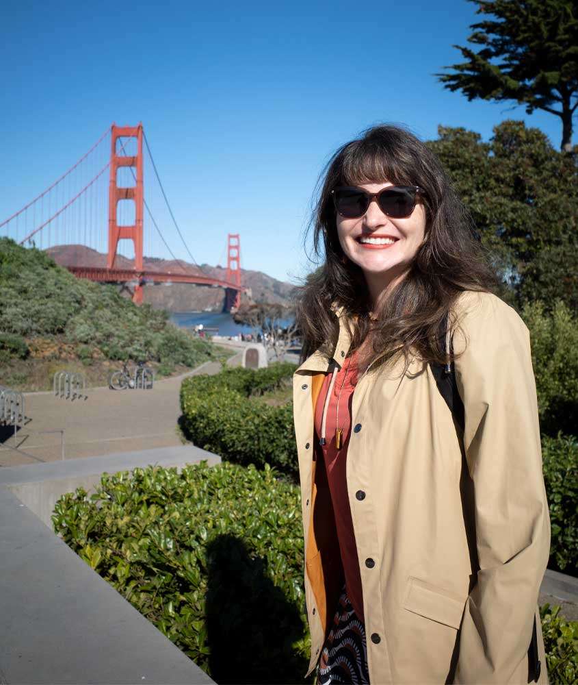 Em um dia de sol, Bárbara Rocha Alcantelado, em San Francisco, uma das melhores cidades para conhecer nos Estados Unidos com árvores e ponte ao redor