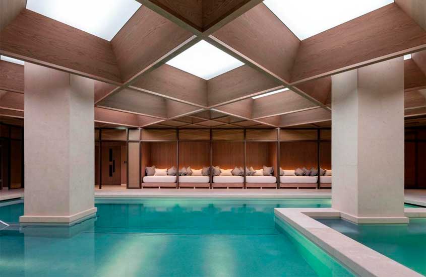 Área de lazer coberta de um dos hotéis em Londres para brasileiros, com piscinas e camas de descanso