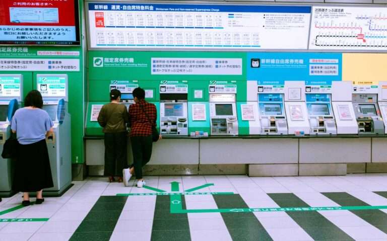 Pessoas recarregando IC card no Japão em máquinas em estação