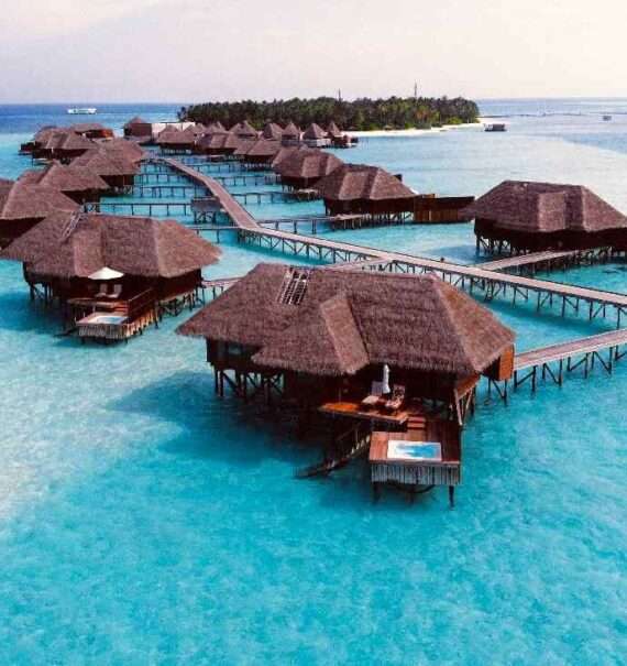 Em um dia de sol, vista aérea de um hotel para passar a lua de mel nas maldivas com vários chalés com piscina