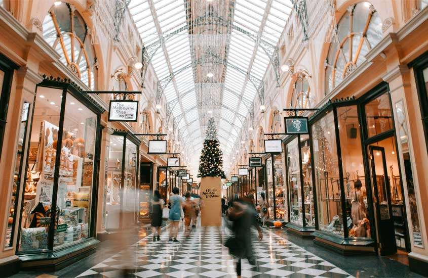 Shopping em Melbourne com pessoas, lojas ao redor e árvore decorativa