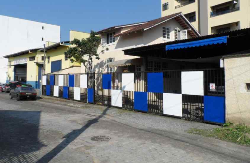 Fachada de um hotel em blumenau perto da oktoberfest com detalhes coloridos e plantas decorativas