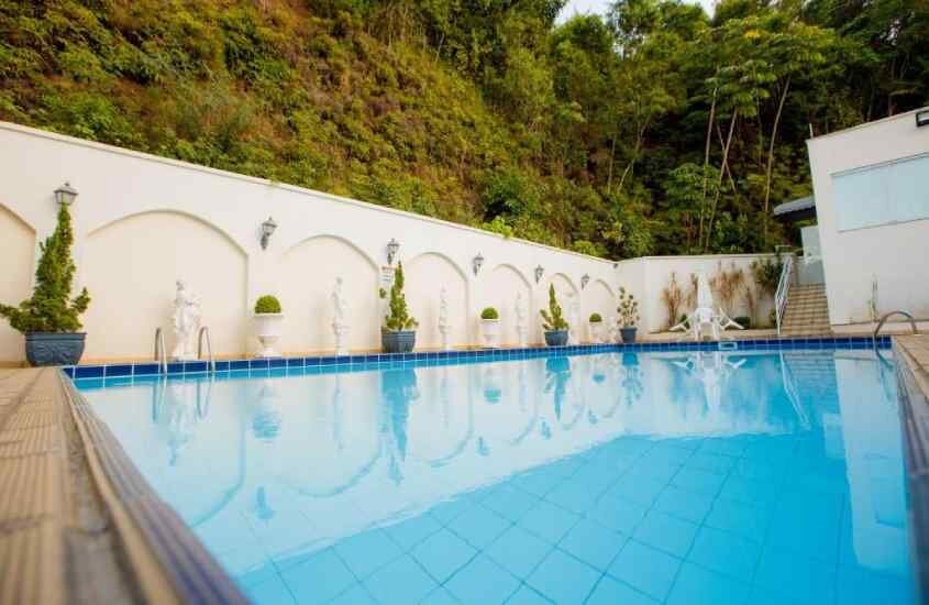 Área de lazer de um hotel perto da oktoberfest blumenau com piscina e plantas decorativas