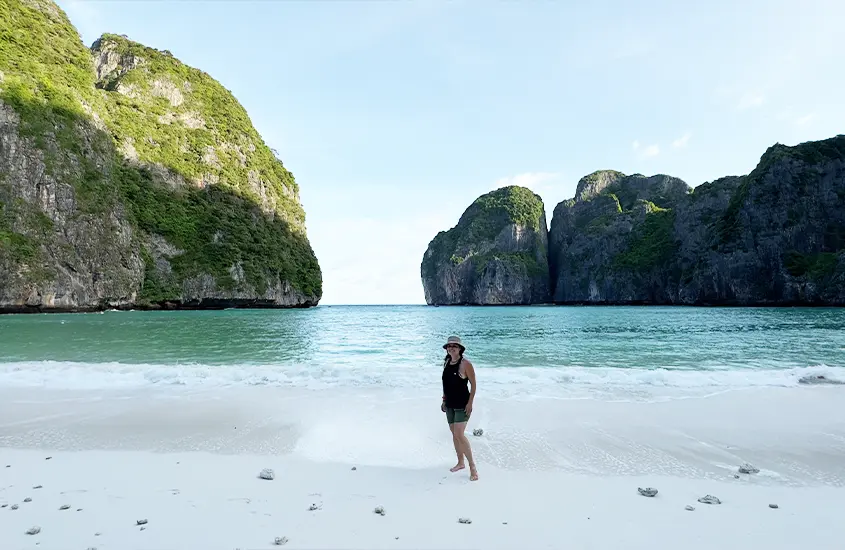 Durante o entardecer, Bárbara Rocha Alcantelado em Maya Bay com paredões de pedra e praia atrás