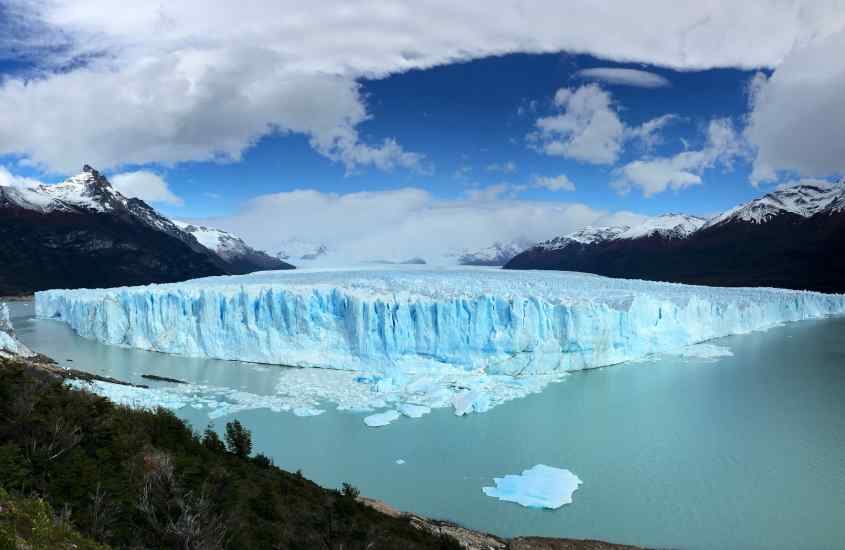 Paisagem de El Calafate, com geleira no meio e árvores ao redor