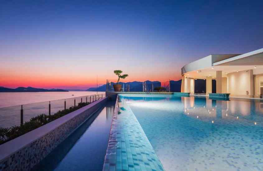 Durante o entardecer, área de piscina de um dos hotéis em Dubrovnik com planta decorativa e paisagem da cidade