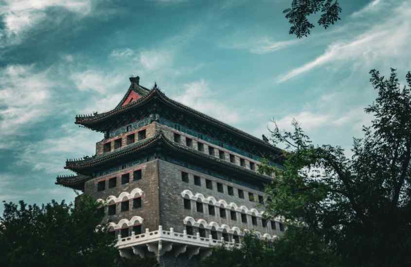 Durante o entardecer, ponto turístico de Qianmen, um dos melhores bairros onde ficar em Pequim com árvores ao redor