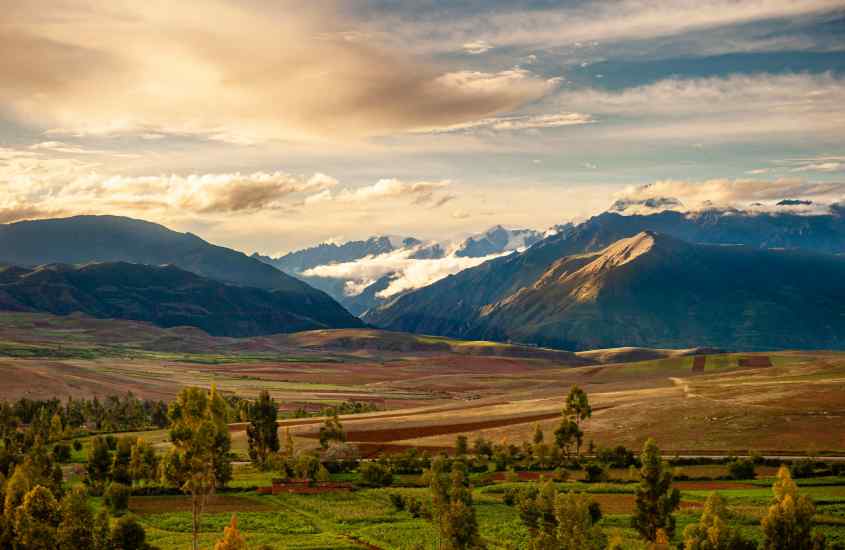 Em um final de tarde, paisagem de Urubamba, uma cidade próxima a machu picchu com montanhas, árvores e plantas ao redor