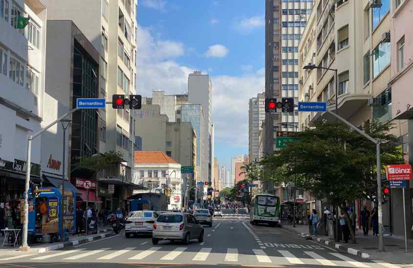 Em um dia de sol, ruas do centro de Campinas, uma cidade perto do hopi hari com carros, árvores e prédios ao redor