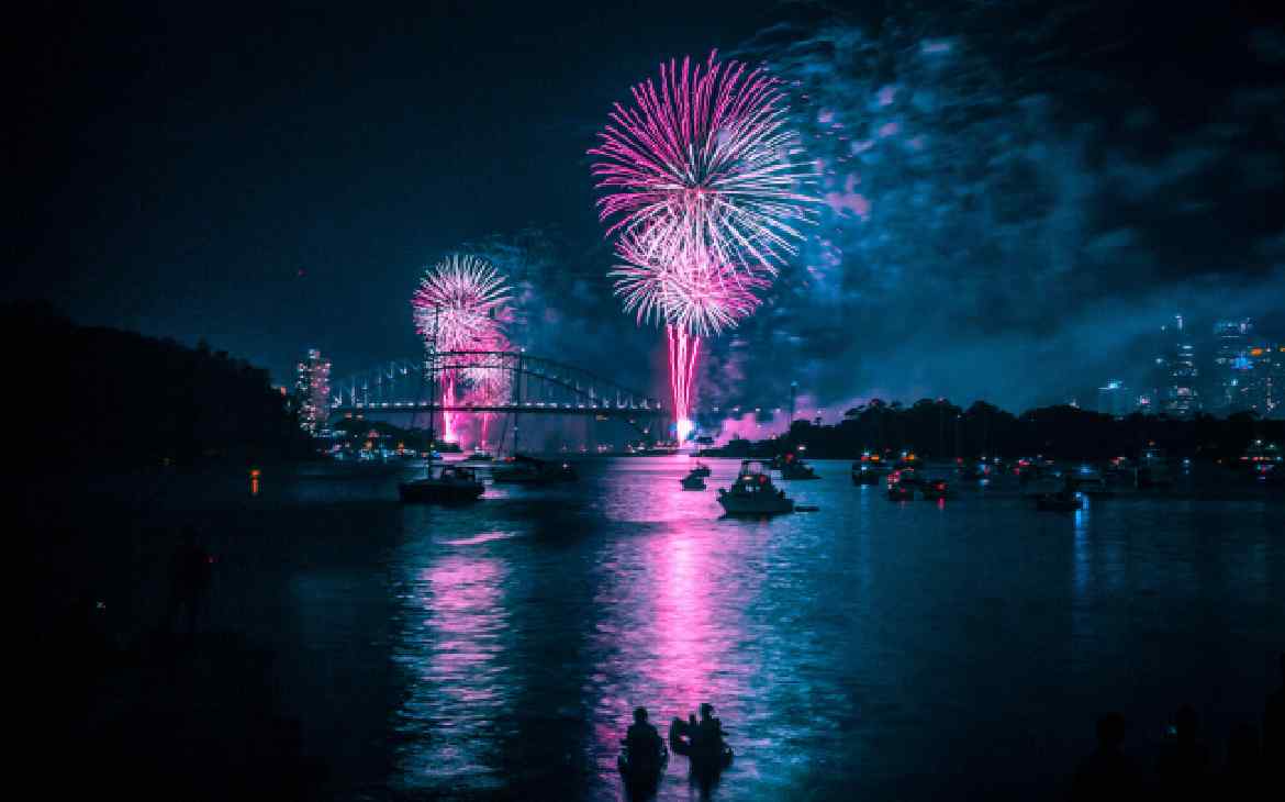 Durante a notie, queima de fogos do Réveillon em Sydney refletidas no mar