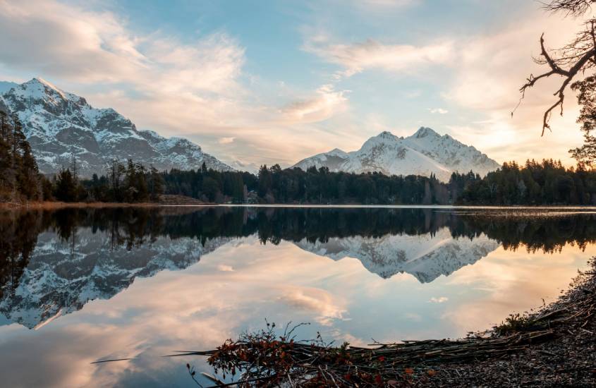 Em um final de tarde, Bariloche com lago no meio, montanhas no fundo e floresta no meio