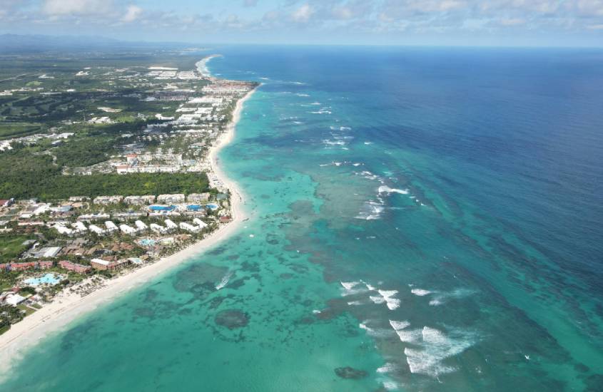 Em um dia de sol, paisagem de Punta Cana, um dos lugares para lua de mel internacional com praia de um lado e ilha do outro