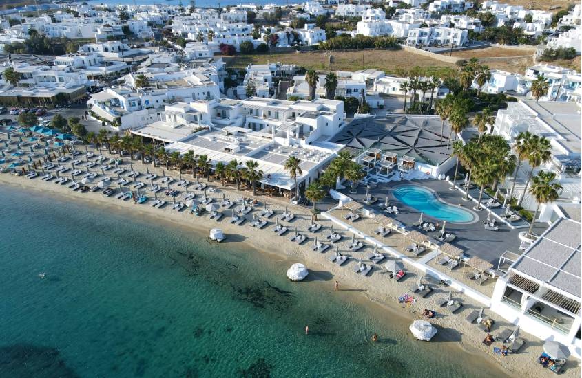 Em um dia de sol, vião aérea de Mykonos, um dos lugares para passar a lua de mel com mar na frente e resorts atrás