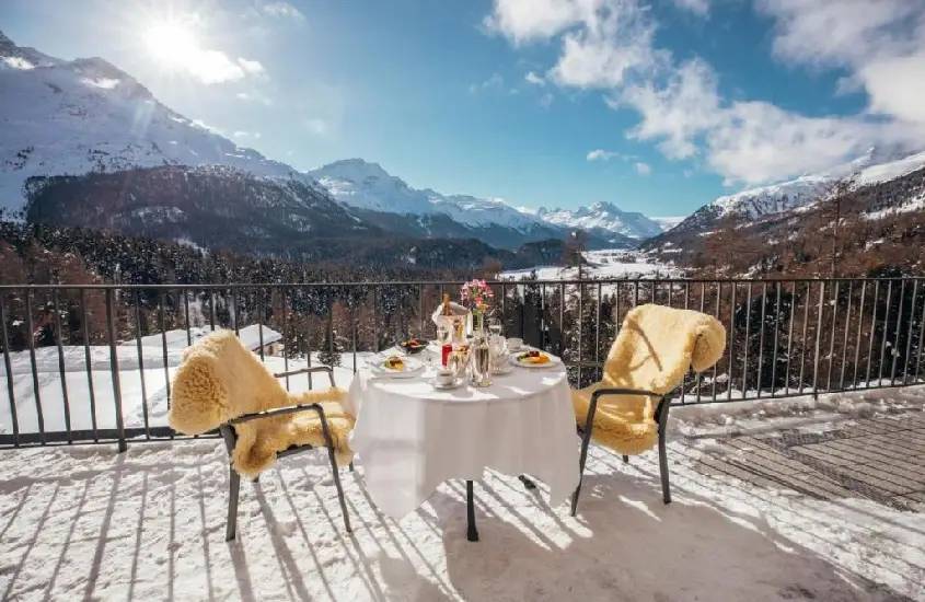 Mesa de café da manhã no Suvretta House em St. Moritz com montanhas nevadas ao fundo durante o dia