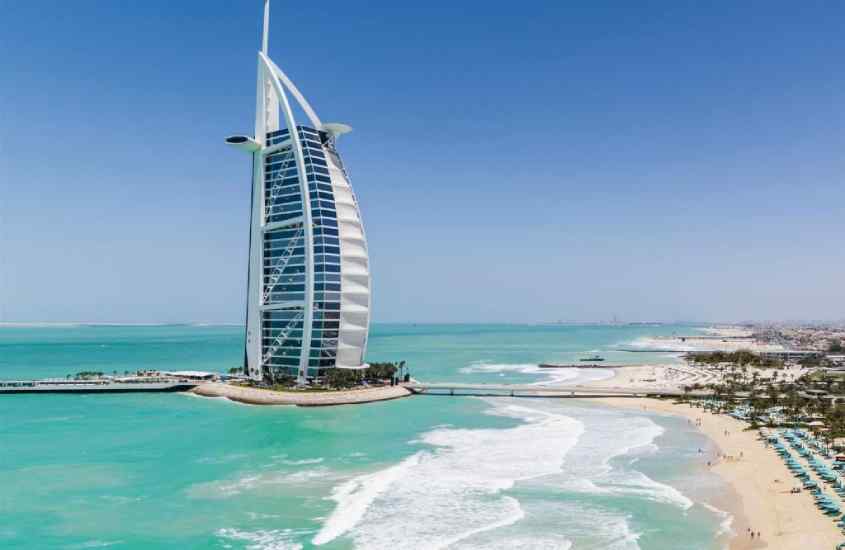 Em um dia ensolarado, paisagem do Burj Al Arab com praia ao lado