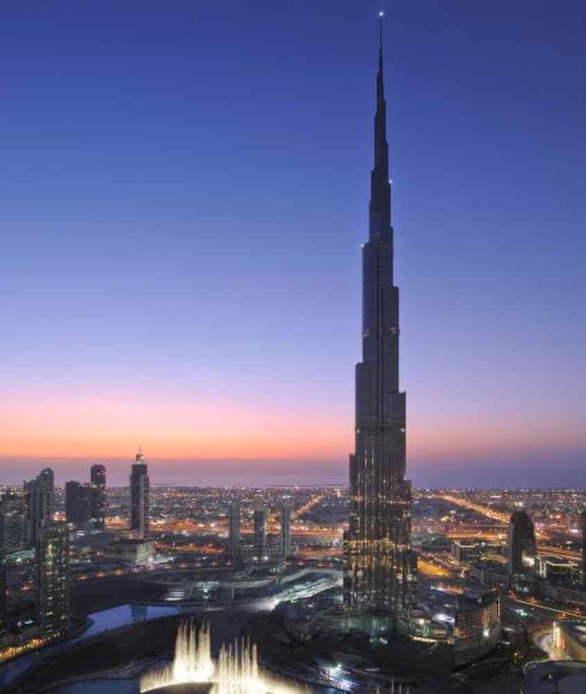 Durante o entardecer, paisagem do Burj Khalifa com cidade iluminada ao redor