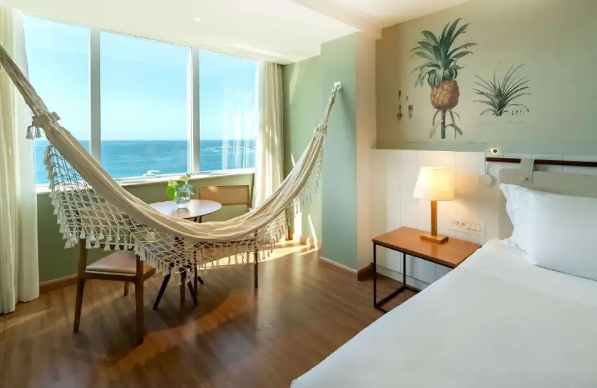 Quarto do Grand Mercure Rio de Janeiro Copacabana com rede e vista para o mar durante o dia