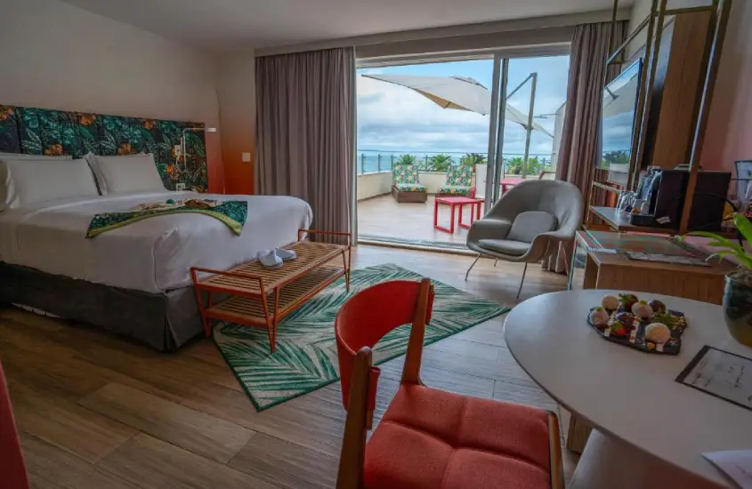 Quarto moderno e elegante no Mercure Rio Boutique Copacabana com varanda e vista para o mar durante o dia