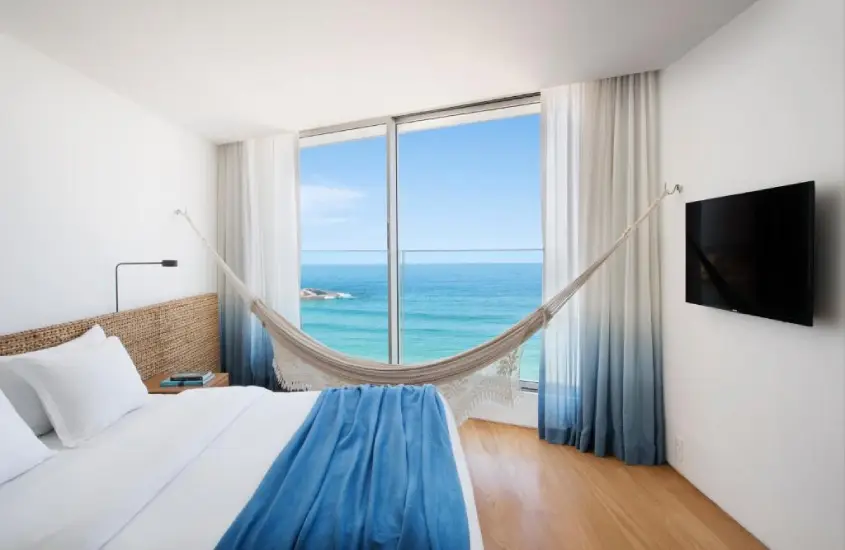 Quarto do Hotel Arpoador com uma rede e vista para o mar durante o dia