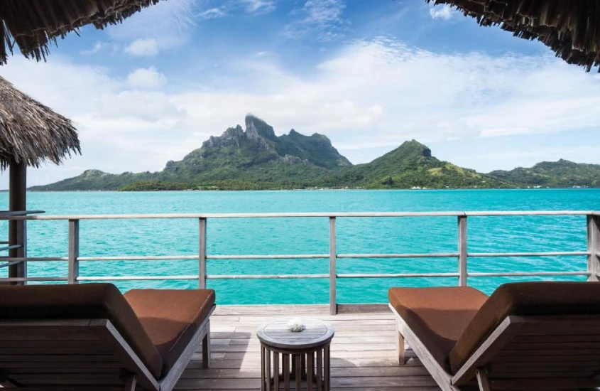 Vista da varanda de um bangalô sobre a água para as montanhas em Bora Bora, Polinésia Francesa