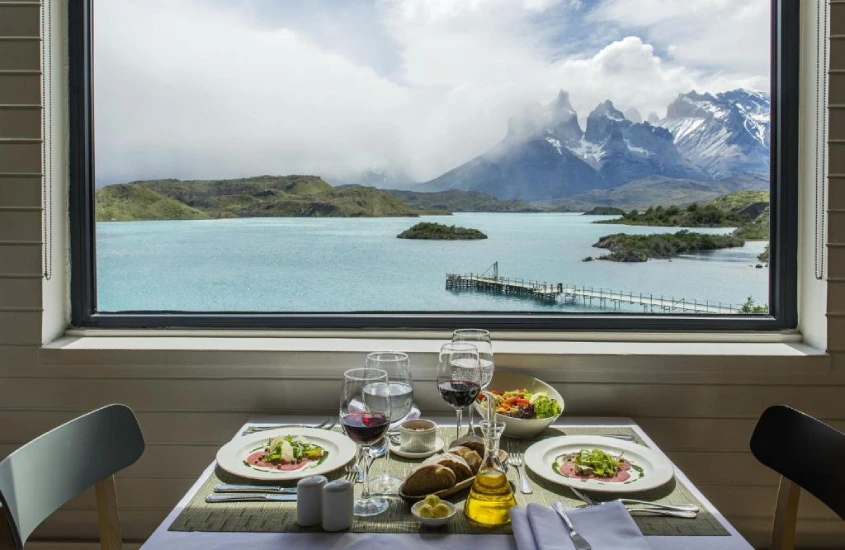 Mesa de jantar com vista para montanhas e um lago na Patagônia em um dos hotéis com as melhores vistas do mundo