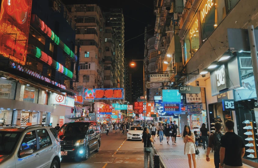 Rua movimentada à noite com letreiros de neon em Hong Kong